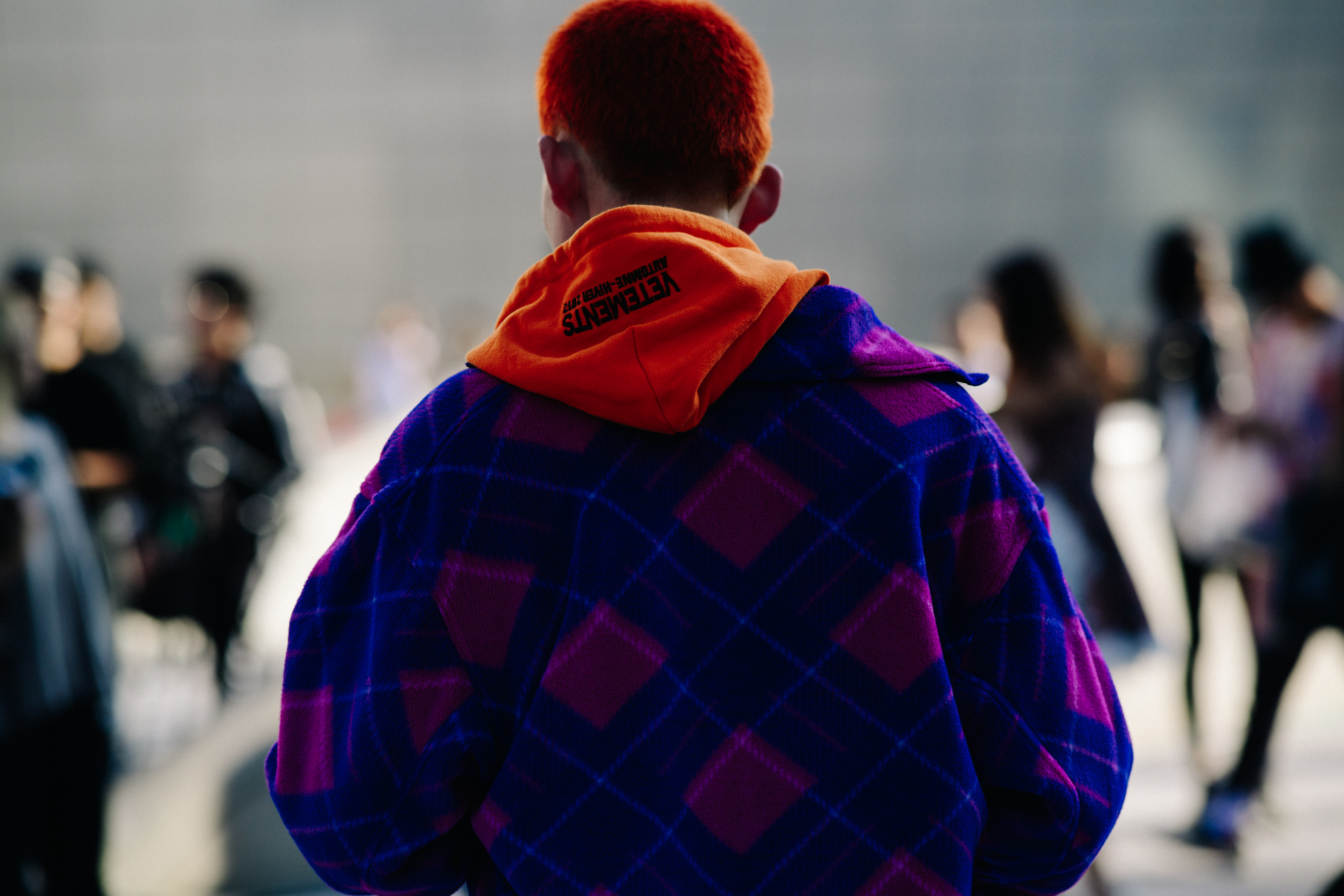 Back of mans head with orange hair and orange Vetements hood